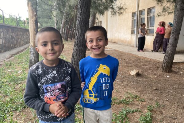 Two kids are posing for a picture in Turkey's area devastated by the recent earthquake.