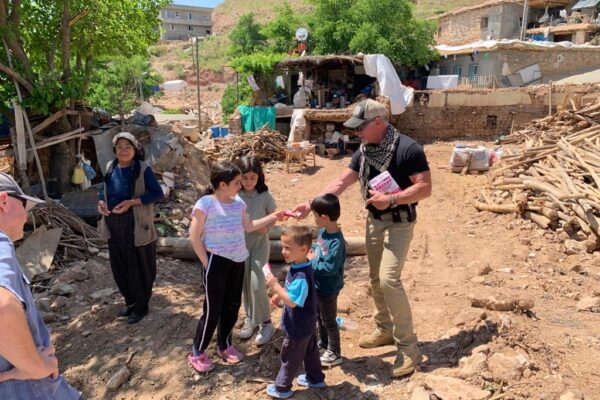 Volunteers from the aid mission share some sweets with kids among their place ruins after the devastation of the recent Turkey earthquake.