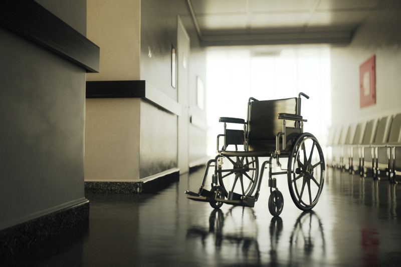 Standard manual wheelchair standing in empty hospital corridor